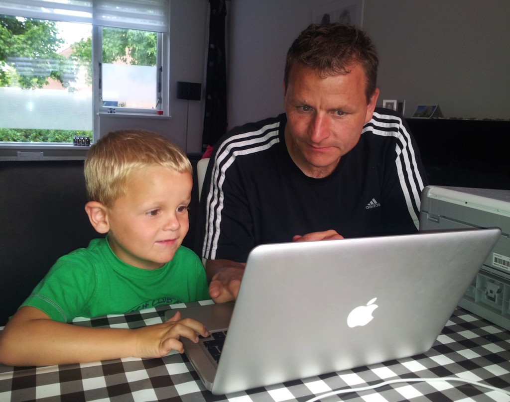 Ouder en kind achter laptop
